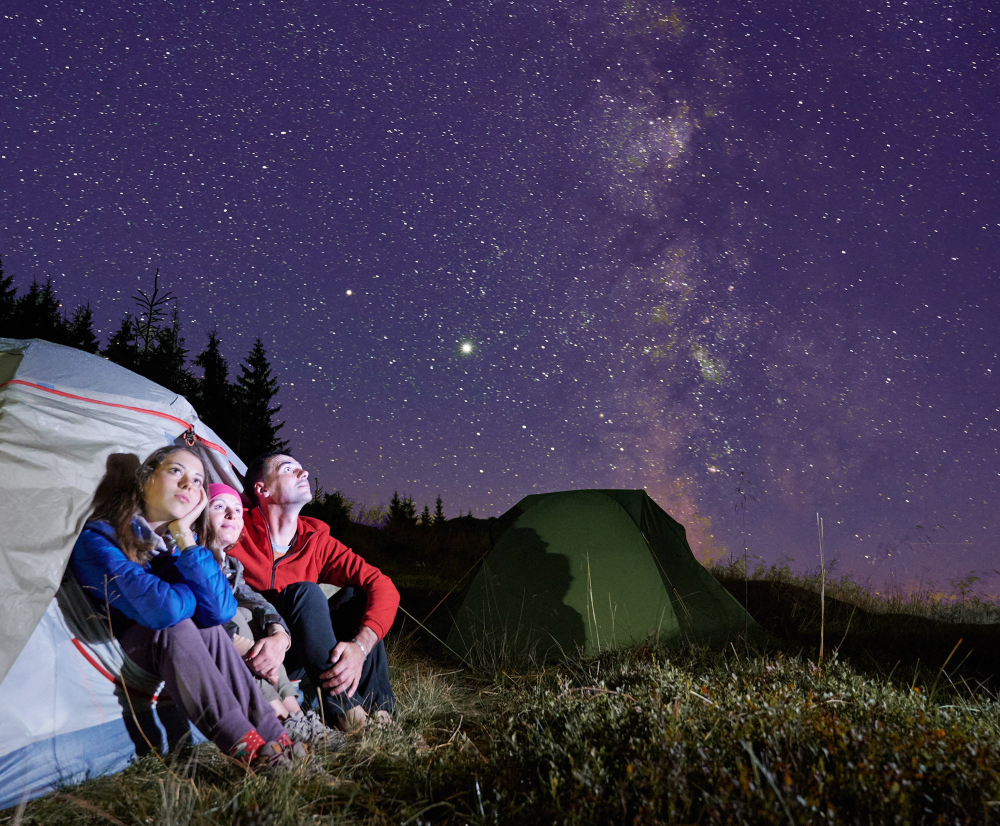 Family in a tent looking at the stars
