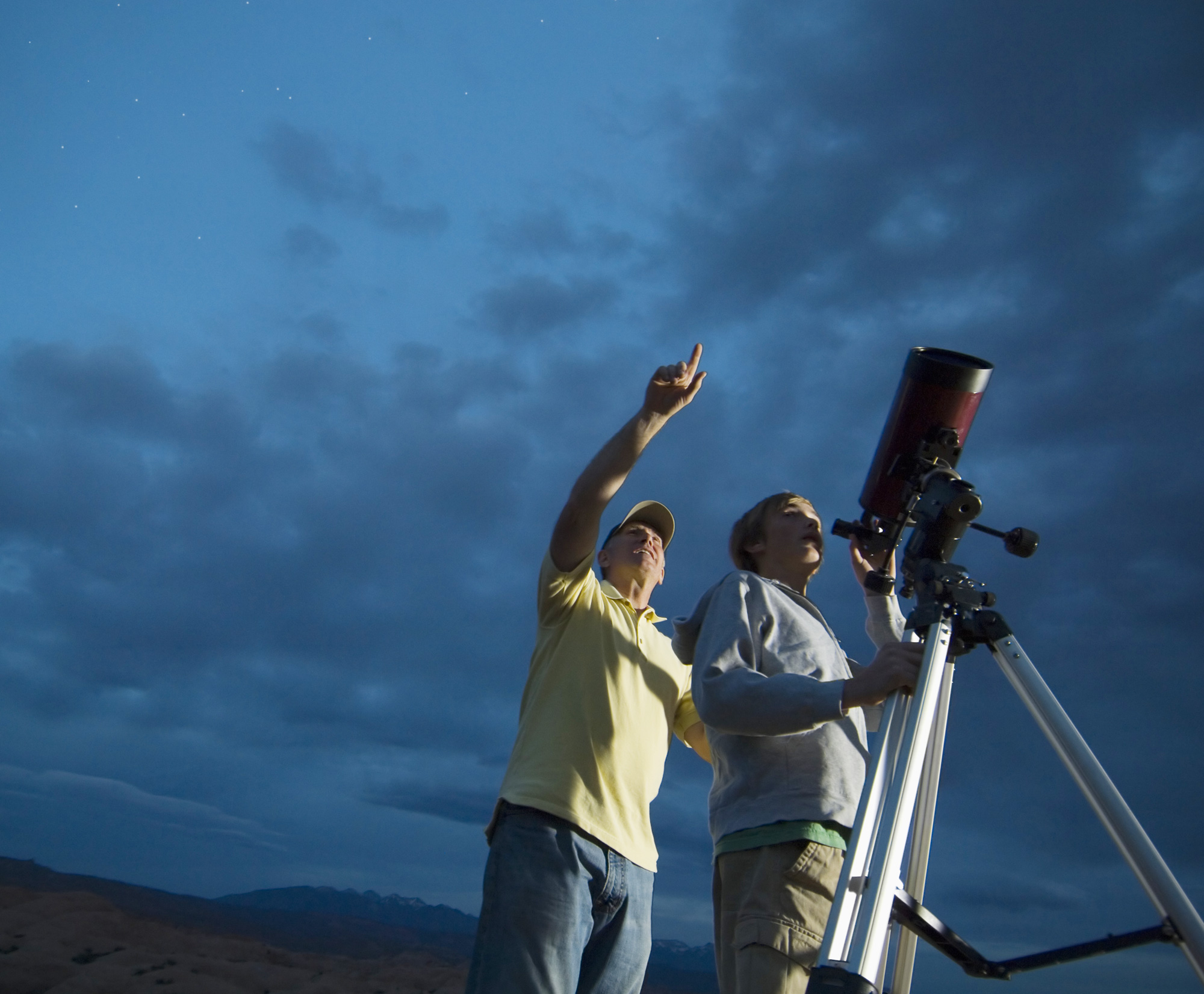 Two people using a telescope to look at the stars